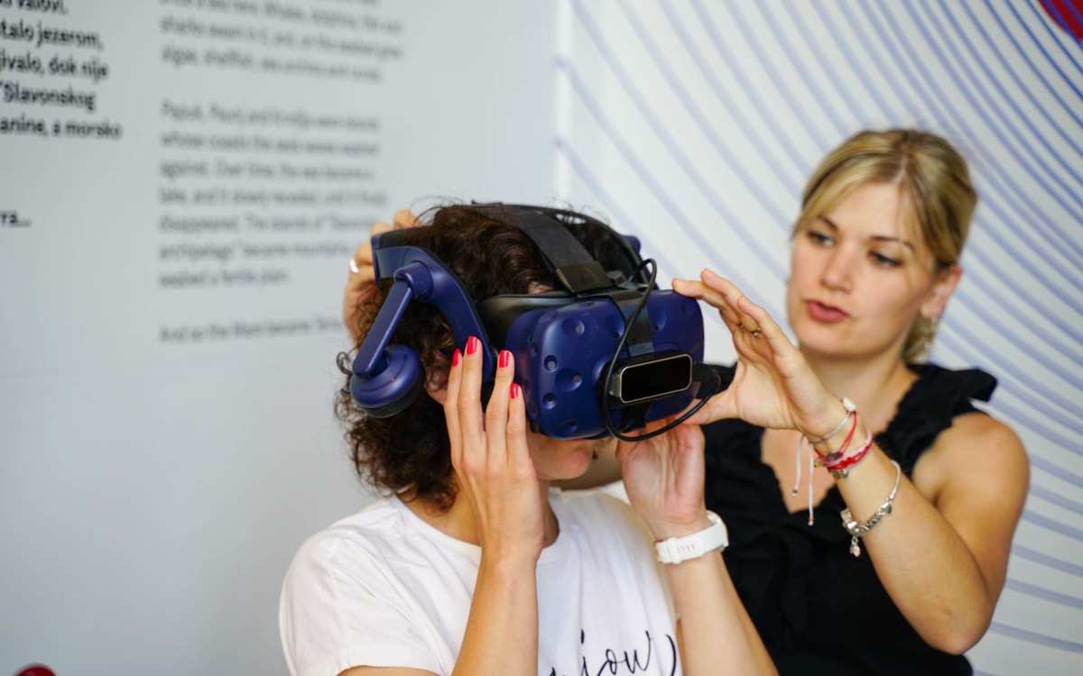 Пользователю помогают надеть VR-шлем